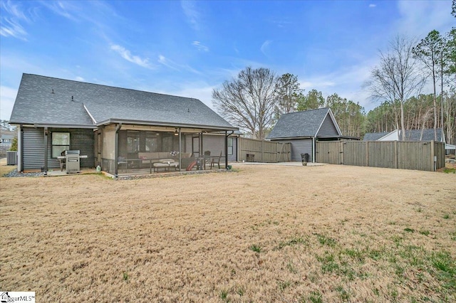 rear view of house featuring a yard, central AC unit, fence, and a sunroom