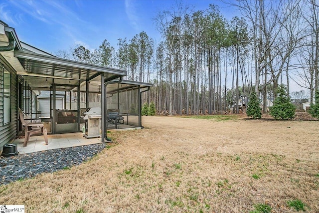 view of yard featuring a sunroom and a patio area