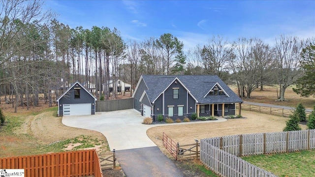 view of front facade featuring a fenced front yard, covered porch, a detached garage, stucco siding, and a front yard