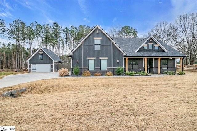 view of front of home with a garage, a shingled roof, fence, an outdoor structure, and a front yard