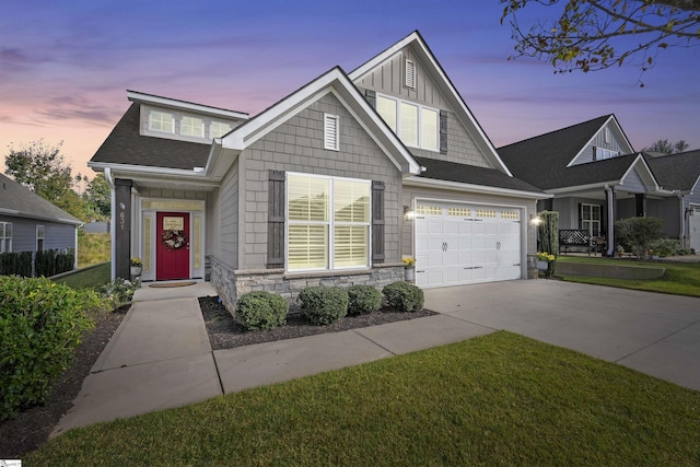 view of front facade with a garage, stone siding, driveway, roof with shingles, and board and batten siding