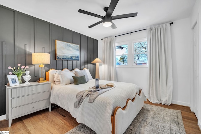 bedroom featuring light wood finished floors, a ceiling fan, and baseboards