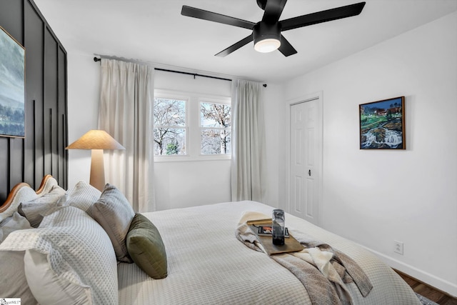 bedroom featuring ceiling fan, baseboards, and wood finished floors