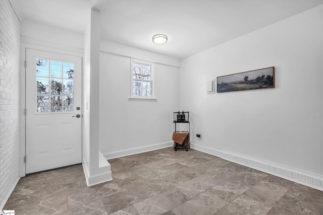 interior space featuring brick wall and baseboards