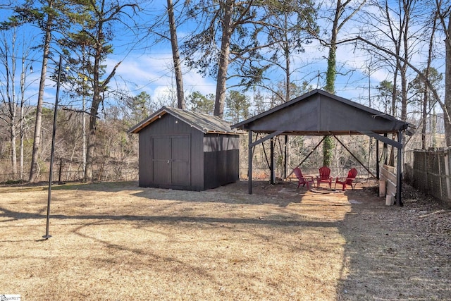 view of yard featuring a gazebo, a storage shed, fence, a carport, and an outdoor structure