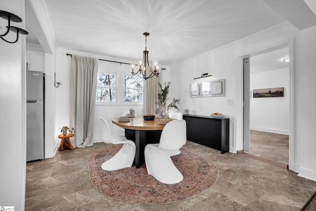 dining area with a chandelier, crown molding, and baseboards