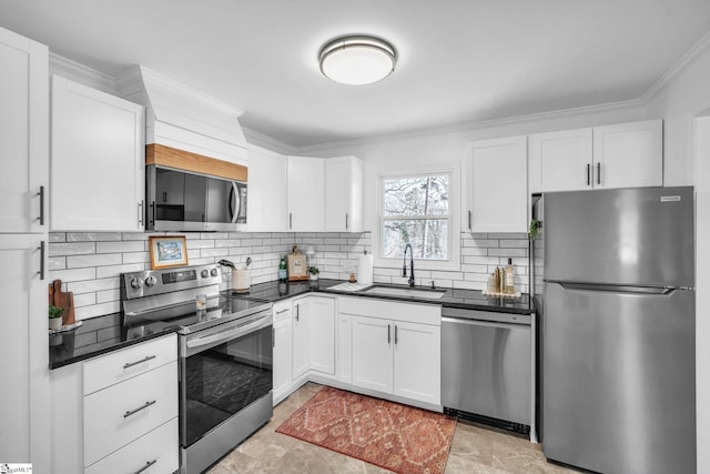 kitchen featuring appliances with stainless steel finishes, dark countertops, white cabinetry, and a sink