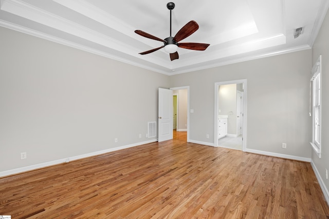 unfurnished bedroom with light wood-type flooring, baseboards, visible vents, and a raised ceiling