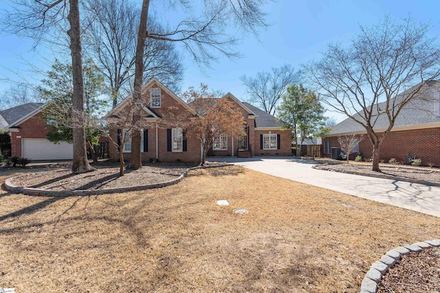 traditional home featuring concrete driveway, brick siding, fence, and a front lawn