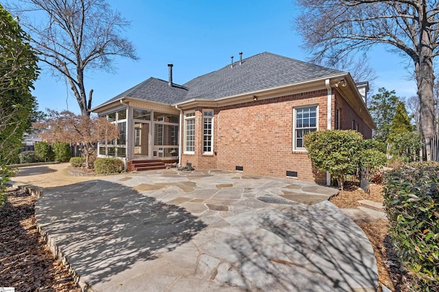 back of house featuring brick siding, a shingled roof, a sunroom, crawl space, and a patio area