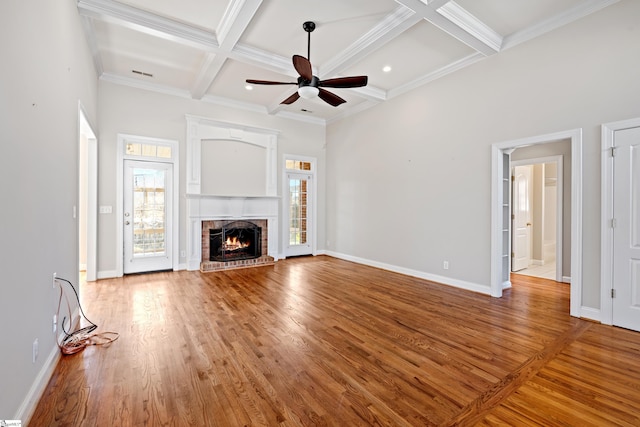 unfurnished living room featuring coffered ceiling, a fireplace, visible vents, and wood finished floors