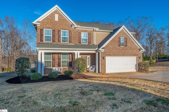 traditional-style home with concrete driveway, an attached garage, covered porch, a front lawn, and brick siding