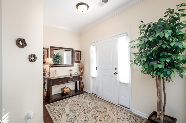 foyer featuring baseboards, visible vents, and ornamental molding