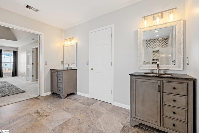 full bathroom featuring two vanities, visible vents, a sink, and baseboards