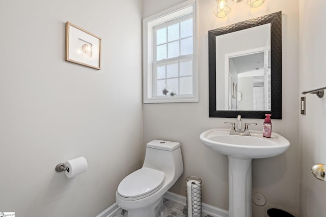 bathroom featuring toilet and baseboards