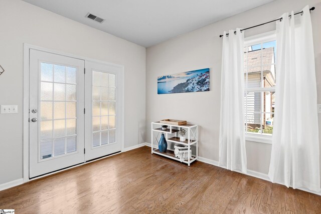 entryway featuring a wealth of natural light, wood finished floors, visible vents, and baseboards