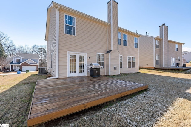 back of house featuring a chimney, cooling unit, and a wooden deck