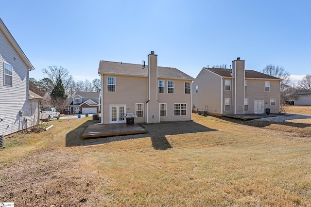 rear view of house with french doors, a yard, a chimney, and central AC unit