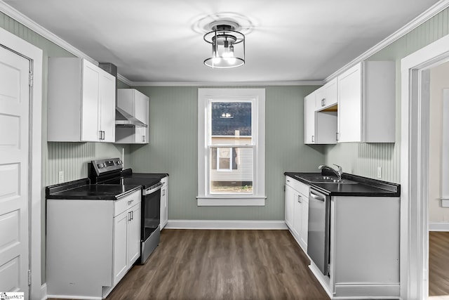 kitchen with dark wood-style floors, stainless steel appliances, dark countertops, a sink, and wall chimney exhaust hood