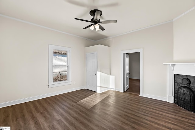 unfurnished living room with dark wood finished floors, a fireplace, crown molding, and baseboards