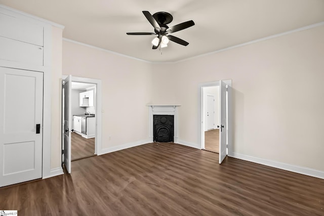 unfurnished living room featuring baseboards, ceiling fan, dark wood-style flooring, crown molding, and a fireplace