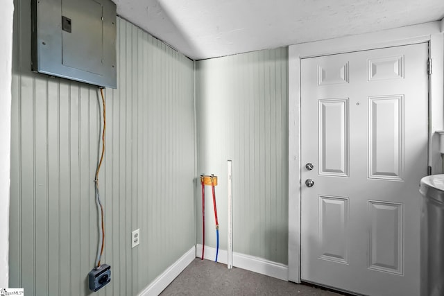 washroom with electric panel and baseboards