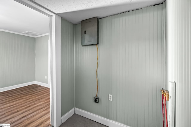 laundry room featuring attic access, electric panel, baseboards, visible vents, and wood finished floors