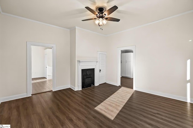 unfurnished living room featuring ceiling fan, dark wood-style flooring, a fireplace, baseboards, and crown molding