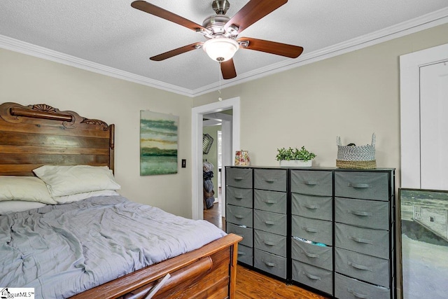 bedroom with a ceiling fan, crown molding, a textured ceiling, and wood finished floors