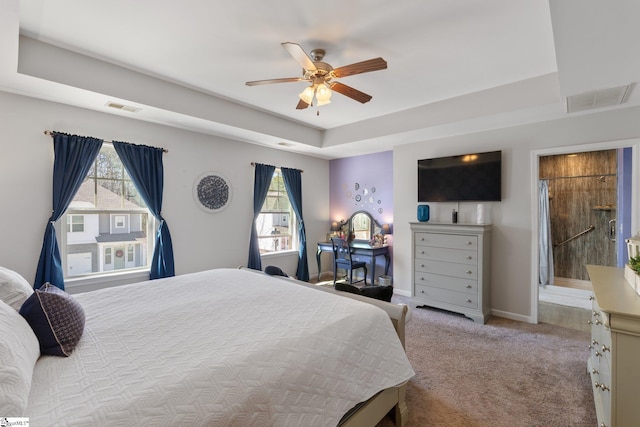 carpeted bedroom with ceiling fan, a raised ceiling, visible vents, and baseboards