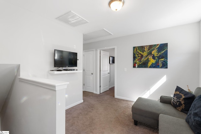 living area with visible vents, carpet floors, attic access, and baseboards