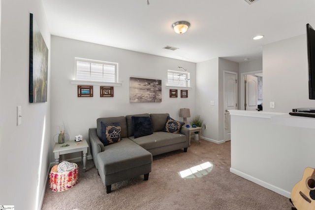 carpeted living room featuring plenty of natural light, visible vents, and baseboards