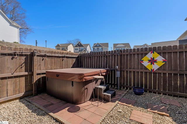 view of patio / terrace with a fenced backyard, a residential view, and a hot tub