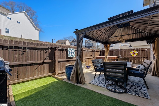 view of patio with a fenced backyard, outdoor dining area, and a gazebo