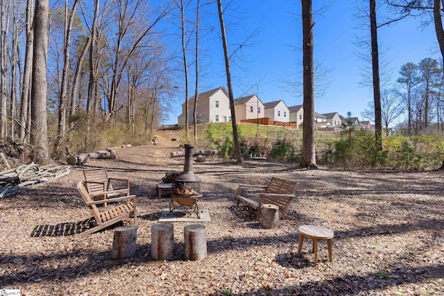 view of yard featuring an outdoor fire pit and a residential view