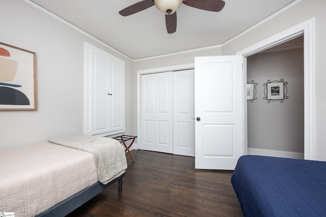 bedroom with crown molding, a closet, dark wood-type flooring, a ceiling fan, and baseboards