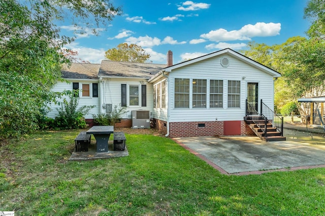 rear view of property with entry steps, a lawn, a chimney, crawl space, and a patio area