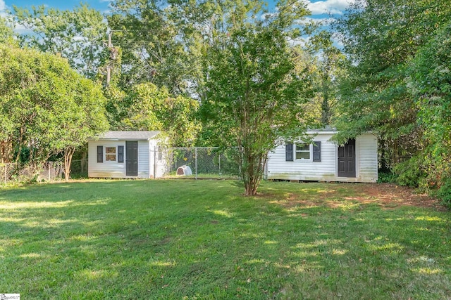 view of front of home with a front lawn, an outdoor structure, and a fenced backyard