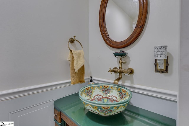 interior details with a wainscoted wall and a sink