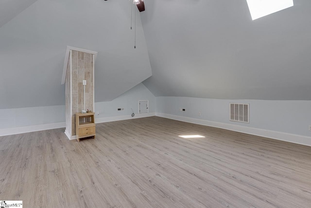 additional living space with visible vents, ceiling fan, vaulted ceiling, wood finished floors, and baseboards