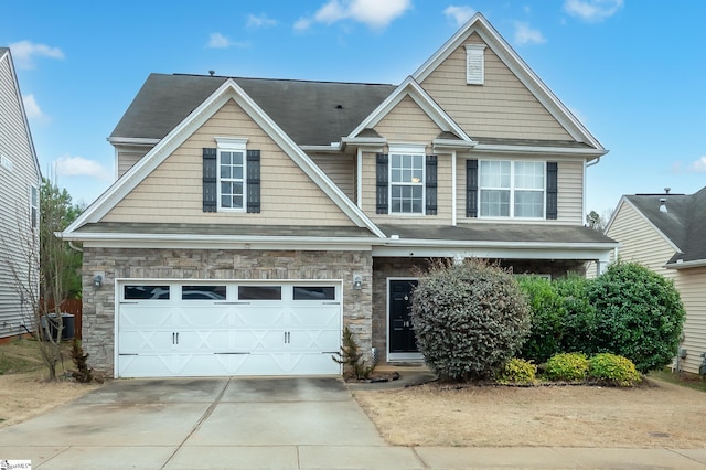 view of front of property featuring cooling unit, stone siding, driveway, and an attached garage