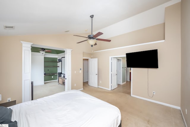 bedroom featuring light carpet, baseboards, visible vents, vaulted ceiling, and ornate columns