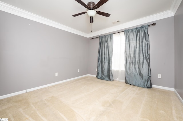 carpeted spare room featuring ceiling fan, visible vents, baseboards, and crown molding