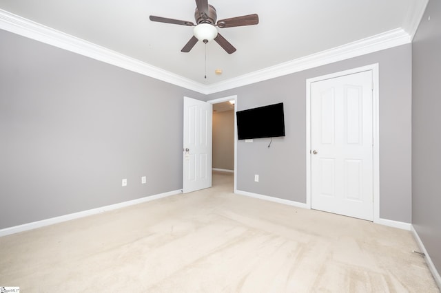 unfurnished bedroom with light carpet, ceiling fan, ornamental molding, and baseboards