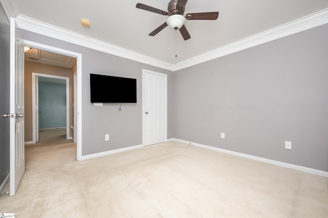 unfurnished bedroom featuring light carpet, attic access, baseboards, ornamental molding, and a closet