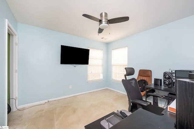 carpeted home office featuring a ceiling fan and baseboards