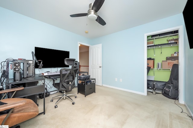 carpeted home office with a ceiling fan and baseboards