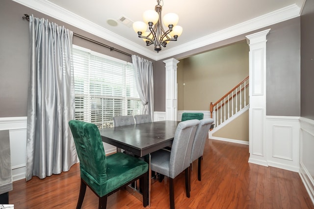 dining space with crown molding, decorative columns, visible vents, wainscoting, and wood finished floors