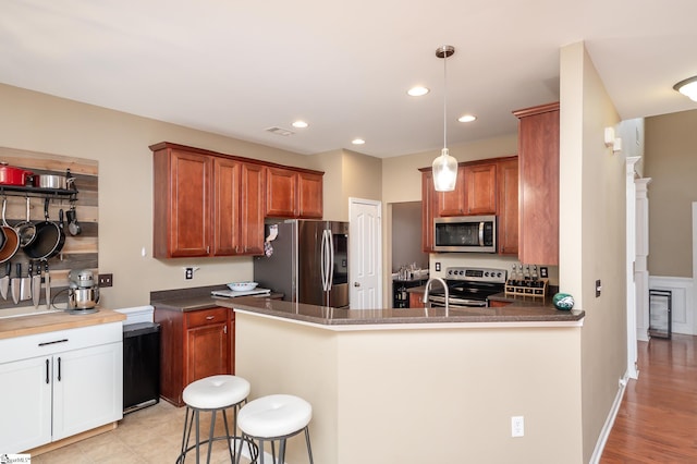 kitchen with recessed lighting, dark countertops, visible vents, appliances with stainless steel finishes, and a peninsula