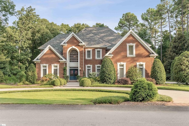 view of front of house with a front yard and brick siding